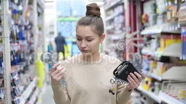 年轻女子在五金店里挑选工作工具